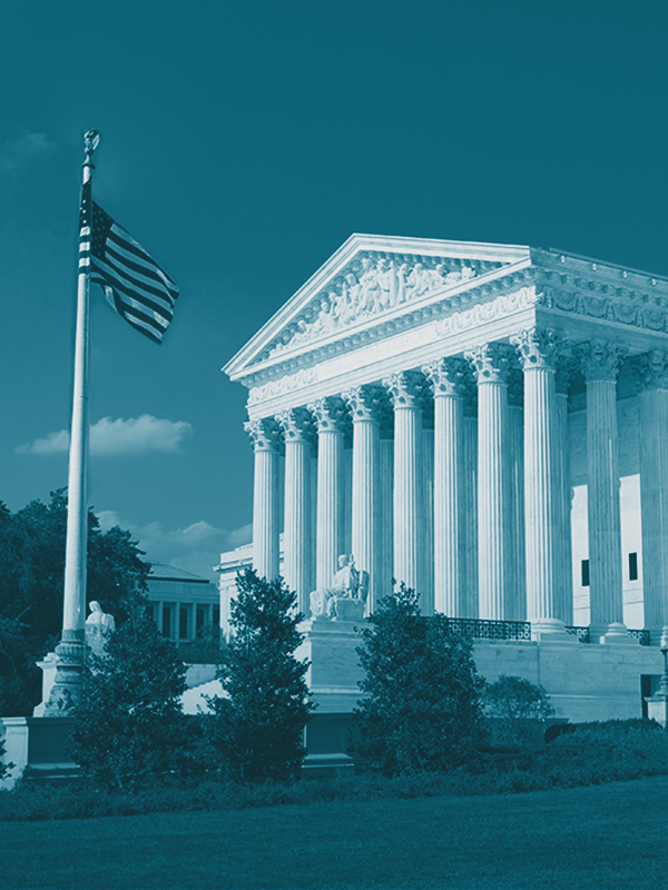 Monochrome image of the United States Supreme Court building with a cyan tone filter, featuring the American flag on the left.